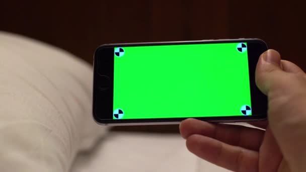 Biały Mężczyzna Pokazać Zielony Ekran Telefon Łóżkiem Białymi Prześcieradłami Pokoju — Wideo stockowe