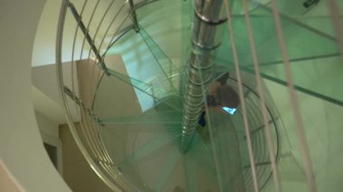 4K, beyaz adam akıllı telefon kullanıyor ve evde merdivenlerden çıkıyor. İç evdeki modern cam merdivenlerde ekran telefonuna dokunuyorum. İnternette sörf yapmak, sosyal ağı kontrol etmek ve metin-Dan yazmak