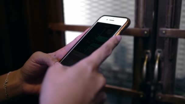 用她的智能手机把亚洲人的手塞住在一座老式小木屋的电梯里 妇女在电话装置中检查社交网络 同时乘坐旧式电梯 — 图库视频影像