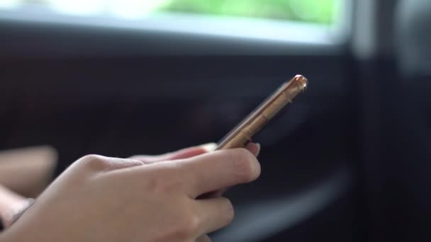 4K亚洲女人在旅行时在车里用手机 检查她手机上的社交网络 用智能手机发短信 — 图库视频影像