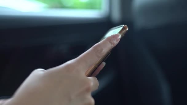 4K亚洲女人在旅行时在车里用手机 检查她手机上的社交网络 用智能手机发短信 — 图库视频影像