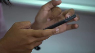 4K kapanış genç öğrencileri telefonda bir mesaj okuyorlar. Sınıftaki ahşap bir masanın üstünde akıllı telefon ekranı gören çocuklar. Bilgi aramak için akıllı telefonu tutan bir genç. Eğitim kavramı. - Dan.