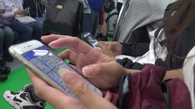 Metro istasyonunda akıllı telefon kullanan 4K 'lı Asyalı kadın, Kore-Dan durağına varmayı beklerken Seul metro haritalarını aşındırıyor.