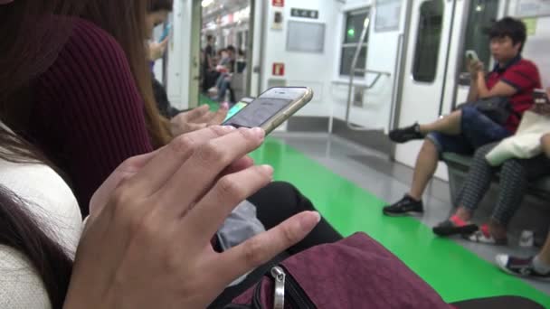 韩国首尔 2015年9月12日 4K亚洲女青年坐在火车上检查她的手机 看她在社交网络上挂起的图片 等待到达她在韩国的车站 — 图库视频影像