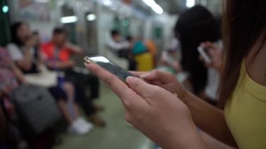 4K Asya 'lı genç bir kadın trende oturup telefonuna bakar ve sosyal ağıyla arkadaşlarıyla mesajlaşır ve Busan, Güney Kore' deki durağına varmasını bekler.