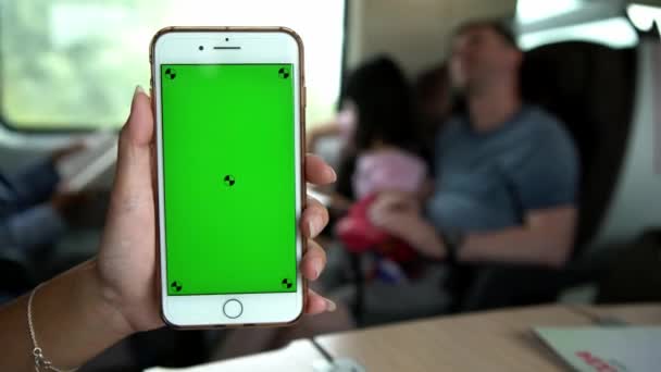 アジアの若い女性の閉じる電車の中で座って イタリアでモックアップの緑の画面電話を表示します 広告にスマートフォンを使う 携帯電話を持っている女性の手 ライフスタイルと交通 Dan — ストック動画