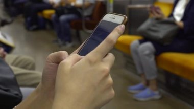 Metroda akıllı telefon kullanan 4K Genç Asyalı kadın. Kız sosyal ağları kontrol ediyor ve Tokyo tren istasyonu Japonya-Dan 'e ait telefon cihazına mesaj yazıyor.