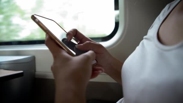 4Kアジアの若い女性が電車に座って イタリアのスマートフォンを使用しています 女性の手の閉鎖は インターネットサーフィンのための携帯電話を保持し ソーシャルネットワークをチェックします 携帯電話を持ってる人 ライフスタイル — ストック動画