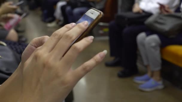4K年轻的亚洲女人在地铁里用智能手机 女孩检查社交网络 并在她的手机上留言 东京火车站 — 图库视频影像