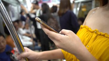 Metroda akıllı telefon kullanan 4K Genç Asyalı kadın. Kız sosyal ağları kontrol ediyor ve Tokyo tren istasyonu Japonya-Dan 'e ait telefon cihazına mesaj yazıyor.