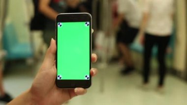 Yaklaş, Asyalı kadın trende yeşil ekranlı telefonu göster, akıllı telefonu bir reklam için kullan, Tayvan-Dan metro istasyonu.