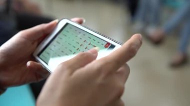 Taipei, Tayvan-22 Mart 2018: 4K Asyalı genç kadın metroda oturmuş telefonla oyun oynuyor. Seyahat, yaşam tarzı ve Tayvan-Dan taşımacılığı için MRT metrosundaki teknoloji akıllı telefonu kullanan yolcular