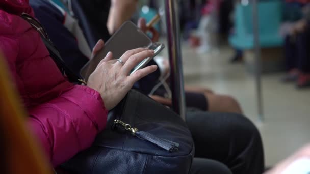 アジアの観光客の女性は地下鉄に座って スマートフォンを保持しています 旅行のための地下鉄で技術電話を使用して乗客 コミュニケーションの手段 ファッショナブルなガジェット ライフスタイルと交通 Dan — ストック動画