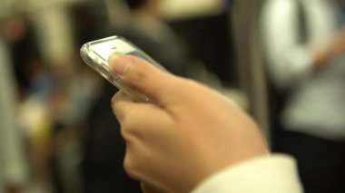 4K Asyalı Kadın trende Smartphone 'u kullanarak sosyal ağını kontrol edip insanlarla iletişim kuruyor. Tayvan-Dan metrosundaki durak istasyonuna varmayı beklerken telefon cihazına bakıyorum.