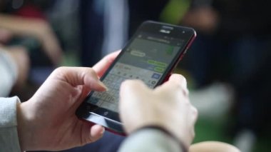 Asyalı genç bir kadın trende oturup telefonuna bakar ve arkadaşlarıyla mesajlaşır hat, sosyal ağ kullanarak, durağı Tayvan 'da beklerken.