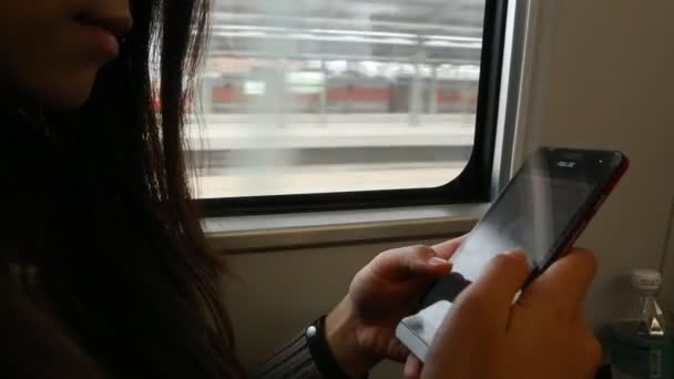 電車の中で待っている女性は 彼女が台湾で彼女の停留所に到着するのを待っているので 彼女の電子メールや文章をチェックするためにスマートフォンを使用して あなたの携帯電話デバイス上でいくつかの仕事を取得するための良い時間です — ストック動画