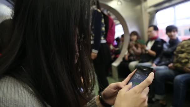 Ασιάτισσα Νεαρή Γυναίκα Κάθεται Ένα Τρένο Ελέγχει Τηλέφωνό Της Και — Αρχείο Βίντεο