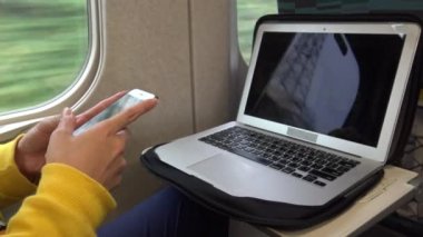 4K Asya 'lı genç bir kadın pencerenin yanında oturmuş telefonuna ve bilgisayarına bakıyor, arkadaşlarıyla mesajlaşırken hat, sosyal ağ kullanıyor, durağı Dan' e varmasını bekliyor.