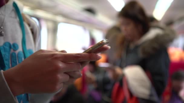 Asian Woman電車の中でスマートフォンを使用して チャットや連絡をするためのソーシャルネットワークを確認してください 台湾の地下鉄駅に到着するのを待っている間に電話機を見る — ストック動画