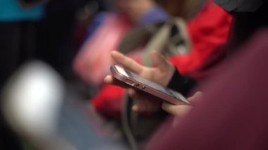 4K Asyalı genç kadın bir trende oturup telefonuna bakıyor ve arkadaşlarıyla mesajlaşırken hat, sosyal ağ kullanarak Tayvan-Dan durağında durmasını bekliyor.