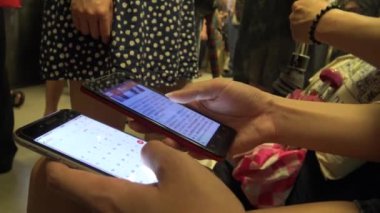 4K Hd Ultra, Asyalı genç kadın bir trende oturuyor iki telefonu kontrol ediyor, sosyal ağda, durağı Tayvan 'da.