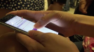 4K Hd Ultra, Asyalı genç kadın trende oturup telefon takvimini kontrol ediyor ve e-posta yazıyor, Tayvan 'daki durağına varmasını beklerken.