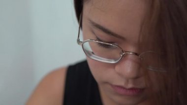 4K Genç Asyalı Gözlüklü Güzel Kız sohbet etmek ve iletişim kurmak için akıllı telefonuna bakıyor. İnternette sörf yapmak için iyi bir zaman, sosyal ağları kontrol etmek ve onun telefon cihazına yapılan metinleri yazmak için.