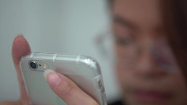 Asyalı Ellerin 4K Yakın Bağlantı Cep Telefonu kullanarak insanlarla sohbet ve iletişim kuruyor. İnternette geziniyor, sosyal ağları kontrol ediyor ve akıllı telefonundan mesaj yazıyor.