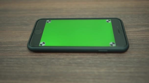 4K绿色荧幕电话的特写 智能手机在一个商业办公室的木桌上 用带有色键的智能手机做广告 — 图库视频影像