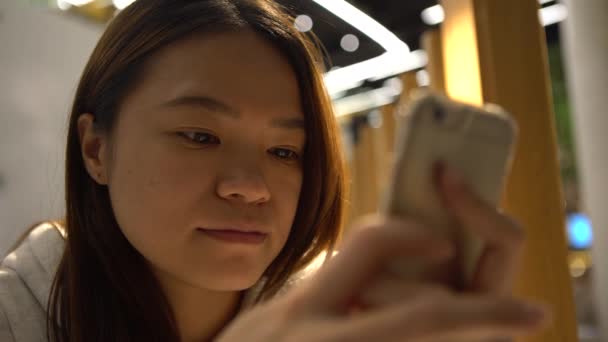 レストランで待っている4K美しいアジアの女性は 彼女が待っているように 彼女の電子メールや文章をチェックするためにスマートフォンを使用して あなたの携帯電話デバイス上でいくつかの仕事を得るための良い時間です Dan — ストック動画