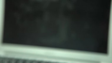 4K. Adamın biri telefonu laptopun yanına götürsün. İş yerinin ahşap masasında akıllı telefonu olan bir bilgisayar. Not defterleri ve akıllı telefon Dan