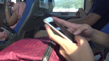 Asyalı Kadın Dokunmatik Ekran Tableti, Akıllı Telefon Cihazı, dokunmatik ped 'de video izleyen genç kadın, sonra otobüste başka bir tane seçiyor, 4K-Dan