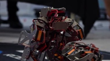 Yarışma robotu teknolojisinin Yavaş Hareketi. Bir çift modern robot kavga ediyor. Akıllı robot dövüşü. Öğrenciler yerde kontrol robotu kullandılar. Mühendislik, teknoloji kampı eğitimi.
