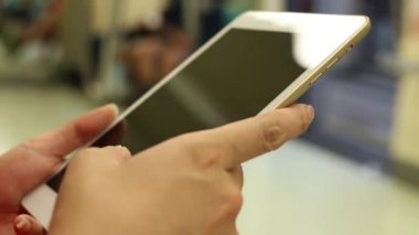 Asyalı genç bir kadın bir trende oturur tablet bilgisayarını kontrol eder, sosyal ağı görür, Tayvan-Dan durağına varmasını bekler.