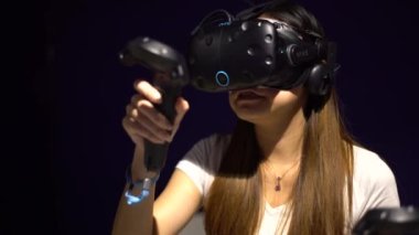 Taipei, Tayvan-01 Aralık 2017: 4K Asyalı kadın gözlük takıyor ve odada sanal gerçeklik oyunu oynuyor. Video oyunları ile birlikte bir baş montajlı ekran kullanıldı. VR modern teknoloji-Dan deneyimi