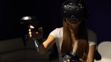 Taipei, Tayvan-01 Aralık 2017: 4K Asyalı kadın gözlük takıyor ve odada sanal gerçeklik oyunu oynuyor. Video oyunları ile birlikte bir baş montajlı ekran kullanıldı. VR modern teknoloji-Dan deneyimi