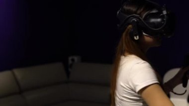 Taipei, Tayvan-01 Aralık 2017: 4K Asyalı kadın gözlük takıyor ve odada sanal gerçeklik oyunu oynuyor. Video oyunları ile birlikte bir baş montajlı ekran kullanıldı. VR modern teknoloji-Dan deneyimi