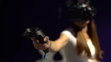 Taipei, Tayvan-01 Aralık 2017: 4K Asyalı kadın gözlük takıyor ve odada sanal gerçeklik oyunu oynuyor. Video oyunları ile birlikte bir baş montajlı ekran kullanıldı. VR modern teknoloji-Dan deneyimi