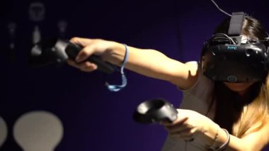 Taipei, Tayvan-01 Aralık 2017: 4K Asyalı kadın gözlük takıyor ve odada sanal gerçeklik oyunu oynuyor. Video oyunları ile birlikte bir baş montajlı ekran kullanıldı. VR modern teknoloji-Dan deneyimi