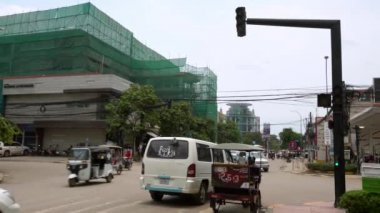 Siem Reap, Kamboçya-17 Nisan 2018: 4K, yol kenarında arabalı trafik ışığı ve tuktuk. Kamboçyalılar eski caddede scooter ve motosiklet sürüyorlar. Şehir merkezinde sahne. -Dan.