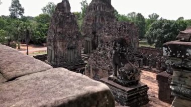 4K, Stone Lion Guardian merdivenler boyunca Pre Rup, Doğu Baray 'daki ormanla birlikte. Siam Reap, Kamboçya 'daki arkeolojik tapınaktaki ihtiyatlı aslanların genel görüşü ve heykelleri.