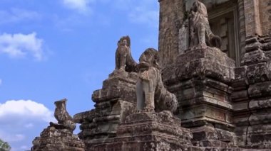 4K, Stone Lion Guardian merdivenler boyunca mavi gökyüzü ve bulutlarla Pre Rup, Doğu Baray 'da. Siam Reap, Kamboçya 'daki arkeolojik tapınaktaki ihtiyatlı aslanların genel görüşü ve heykelleri.