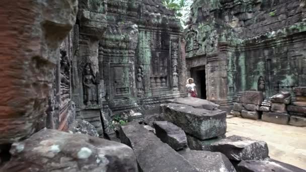 美しいアジアの女性はTa Somの古代ヒンズー教の寺院で散歩します 観光客の少女は アンコールトムの歴史的なエリアであるサイアム リアップの考古学寺院の壁を一人で歩く カンボジア団 — ストック動画