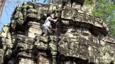 Siem Reap, Kamboçya 19 Nisan 2018: 4K, Bekçi Ta Prohm tapınağını temizledi. Personel Angkor Thom kompleksinde bir kuleyi temizliyor. Tamirat ve restorasyon için çalışan ünlü işadamı Dan.