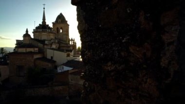 4K, güzel günbatımı. İspanya 'nın otonom bölgelerinden biri olan Extremadura' nın Badajoz eyaletine bağlı Jerez de los Caballeros kasabasındaki Katolik kilisesinin hava manzarası. İspanya - Dan