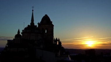 4K, güzel günbatımı. İspanya 'nın otonom bölgelerinden biri olan Extremadura' nın Badajoz eyaletine bağlı Jerez de los Caballeros kasabasındaki Katolik kilisesinin hava manzarası. İspanya - Dan