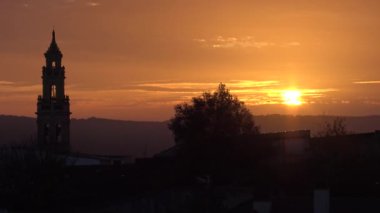 4K, güzel günbatımı. İspanya 'nın otonom bölgelerinden biri olan Extremadura' nın Badajoz eyaletine bağlı Jerez de los Caballeros kasabasındaki Katolik kilisesinin hava manzarası. İspanya - Dan