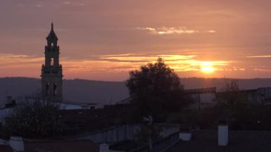 4K, güzel günbatımı. İspanya 'nın otonom bölgelerinden biri olan Extremadura' nın Badajoz eyaletine bağlı Jerez de los Caballeros kasabasındaki Katolik kilisesinin hava manzarası. İspanya - Dan