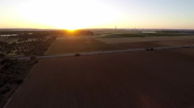 4K, kırsal alanda uzanan güzel tarlalar manzaralı tepede güneş batmadan hemen önce İspanya 'da parlıyor. Çiftliğin yukarısında. Kırsal manzara - Dan