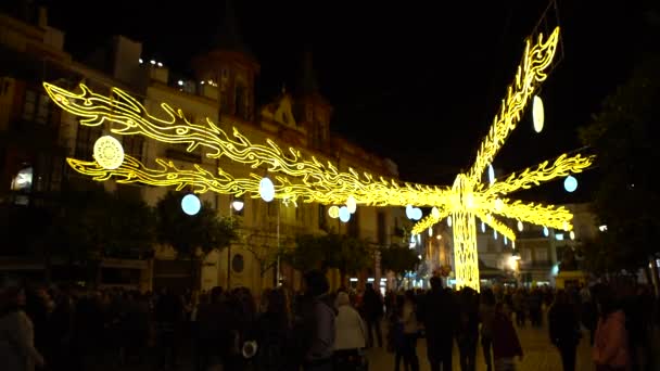 2016年12月10日スペイン セビリア 夜のセビリア中心部のストリートフェスティバルでの光と装飾が施された4K美しいクリスマスツリー 人ダンとの背景都市広場 — ストック動画